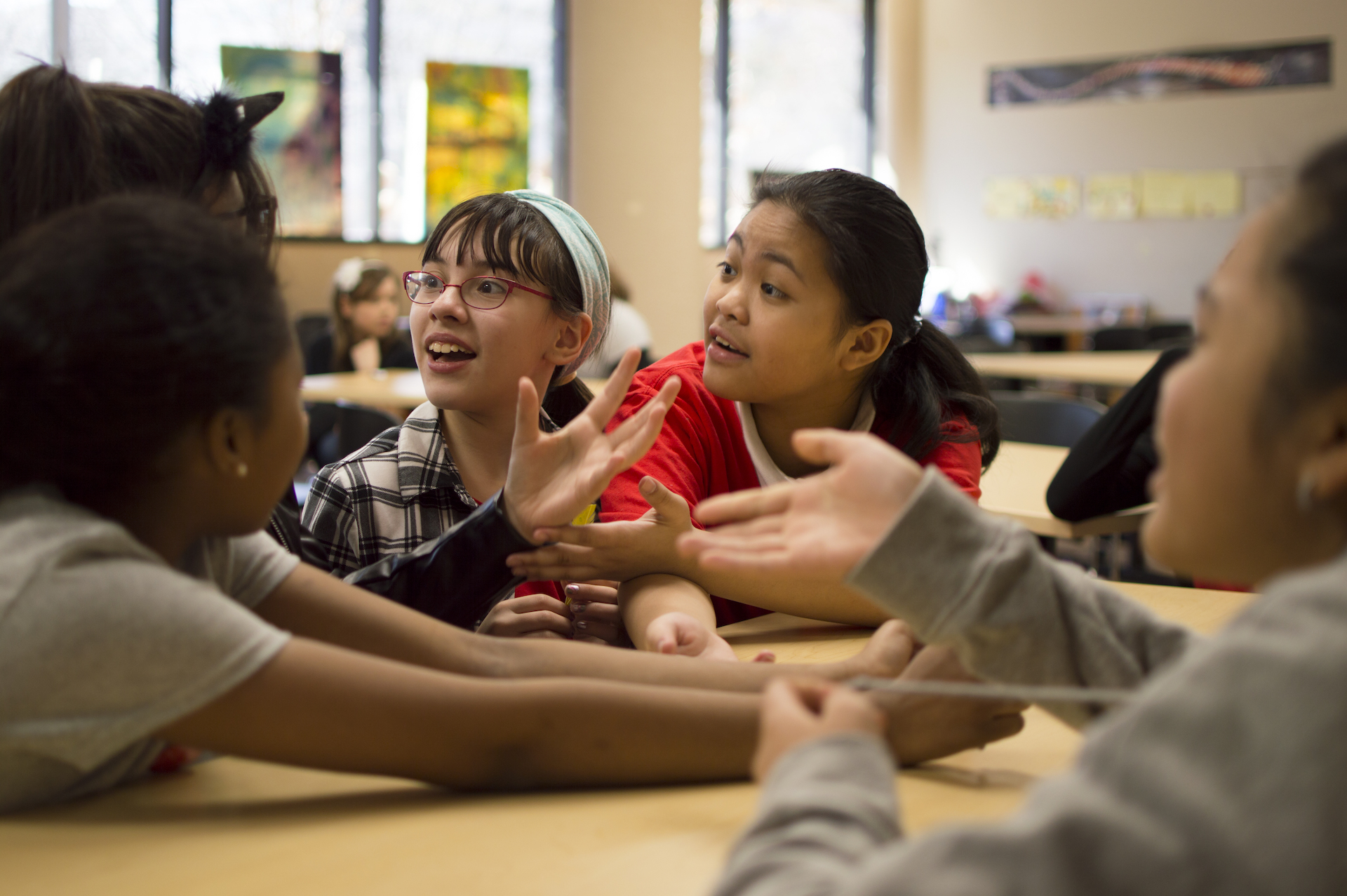 Group of young girls talking to each other at a table in the Power to Girls program