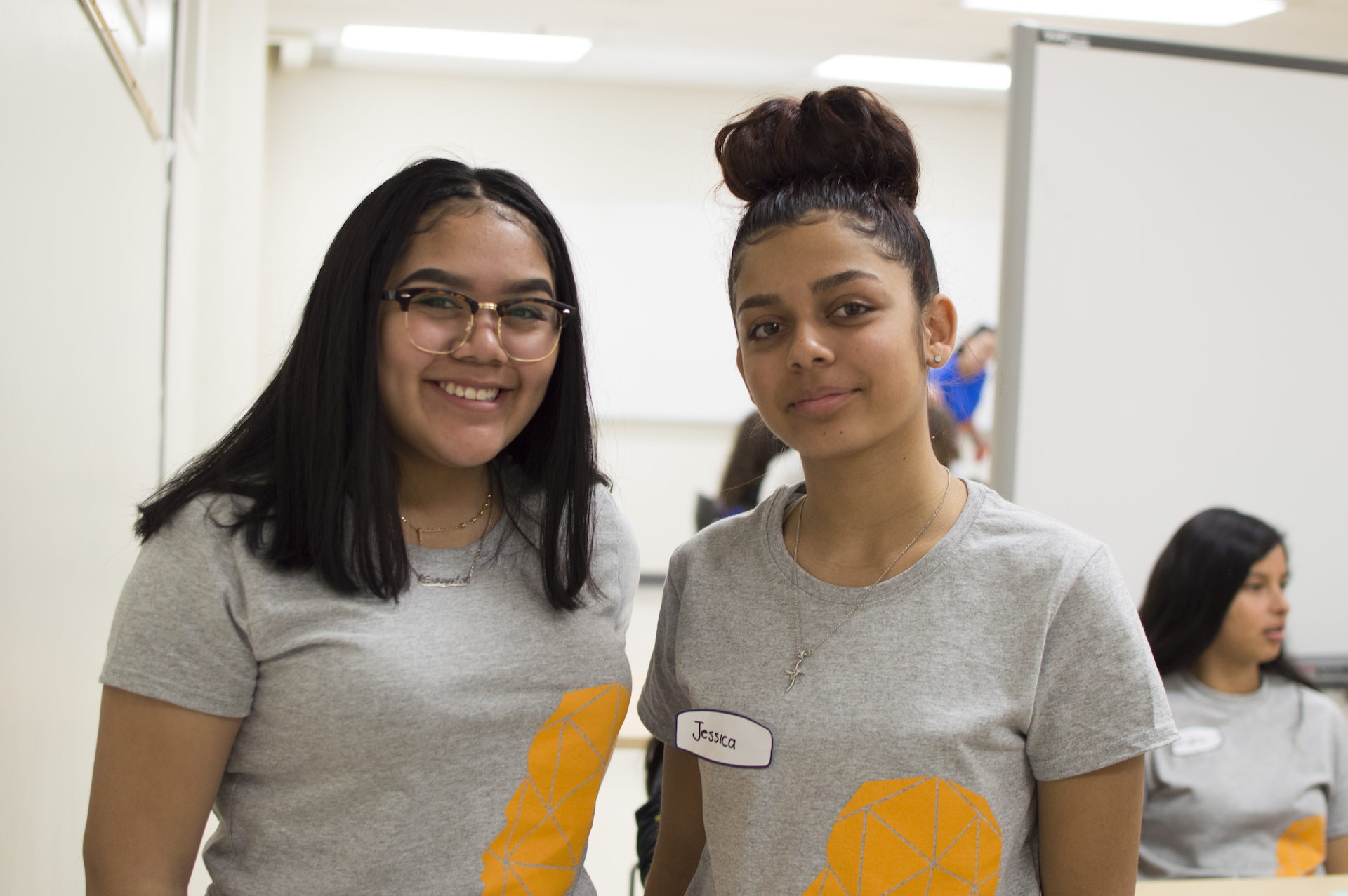 Two Power to Girls volunteers and mentors smiling at the camera during a program